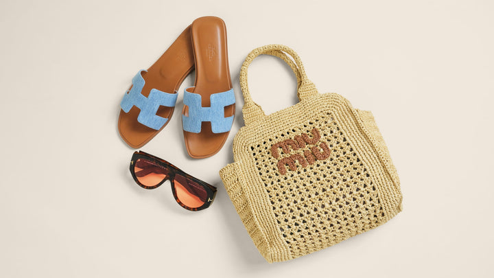 Hermes Oran sandals, a Miu Miu crochet tote, and Tom Ford sunglasses arranged in the center