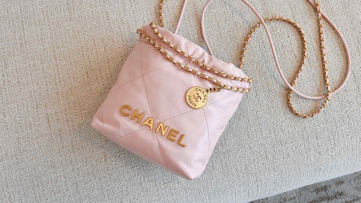 lifestyle image of pink mini chanel 22 bag laying on the couch FASHIONPHILE