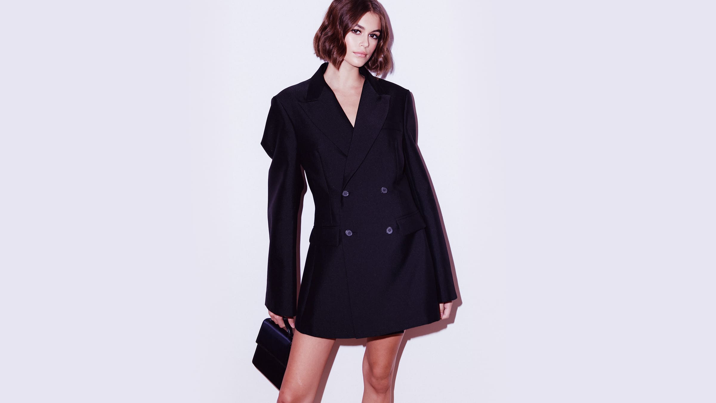 kaia gerber in a suit dress with handbag
