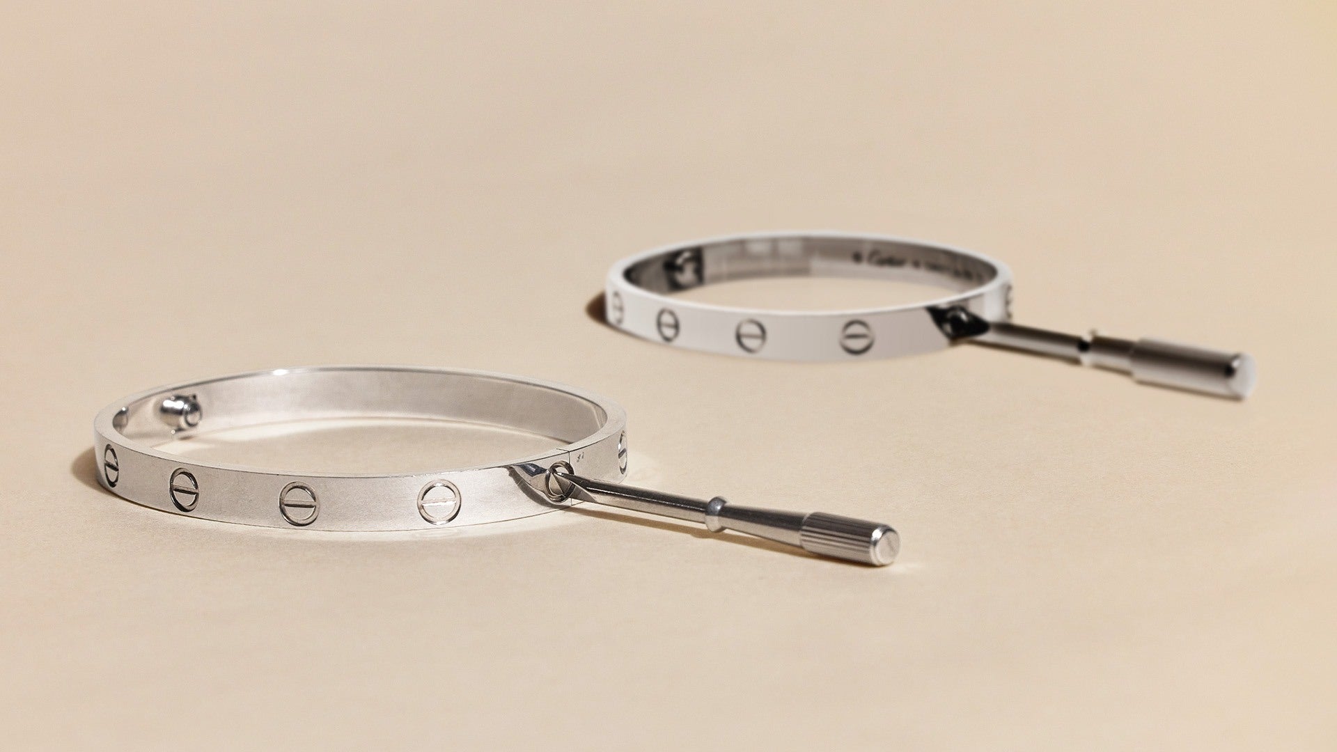 studio image of authentic and fake cartier white gold love bracelets FASHIONPHILE