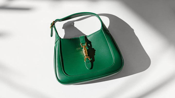 Flatlay image of a Gucci Jackie 1961 bag in the color green by FASHIONPHILE