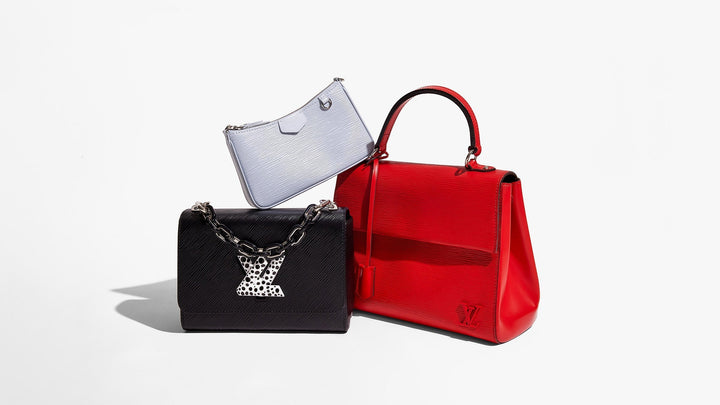this is a studio image by FASHIONPHILE of red, black and blue louis vuitton epi leather bags grouped together