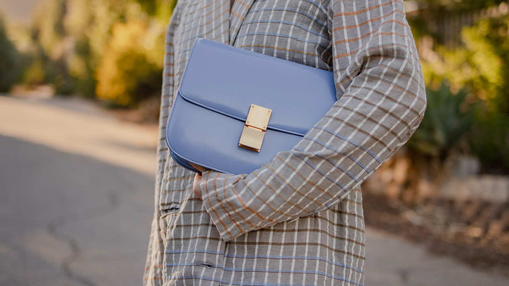 lifestyle image of model holding blue celine box bag FASHIONPHILE