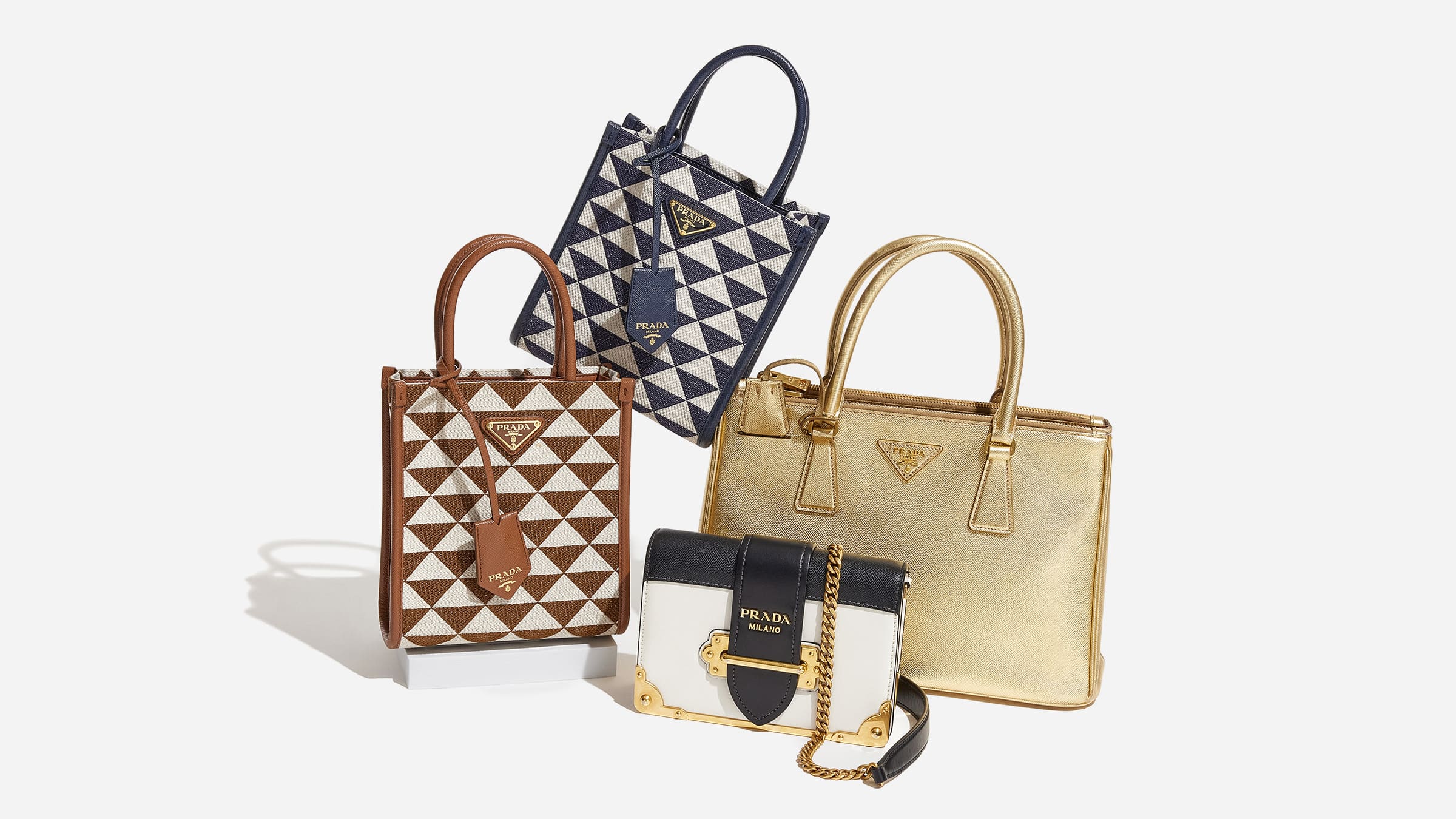 different prada bags grouped together included the Prada symbole tote, the Prada Cahier bag, and the Prada Galleria tote by FASHIONPHILE