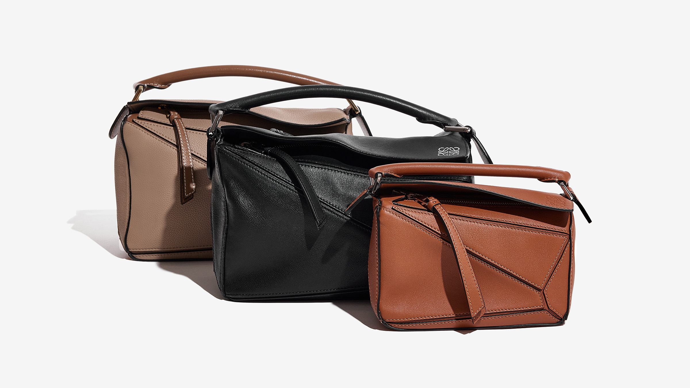 three different neutra-colored loewe puzzle bag sizes grouped together for comparison by fashionphile