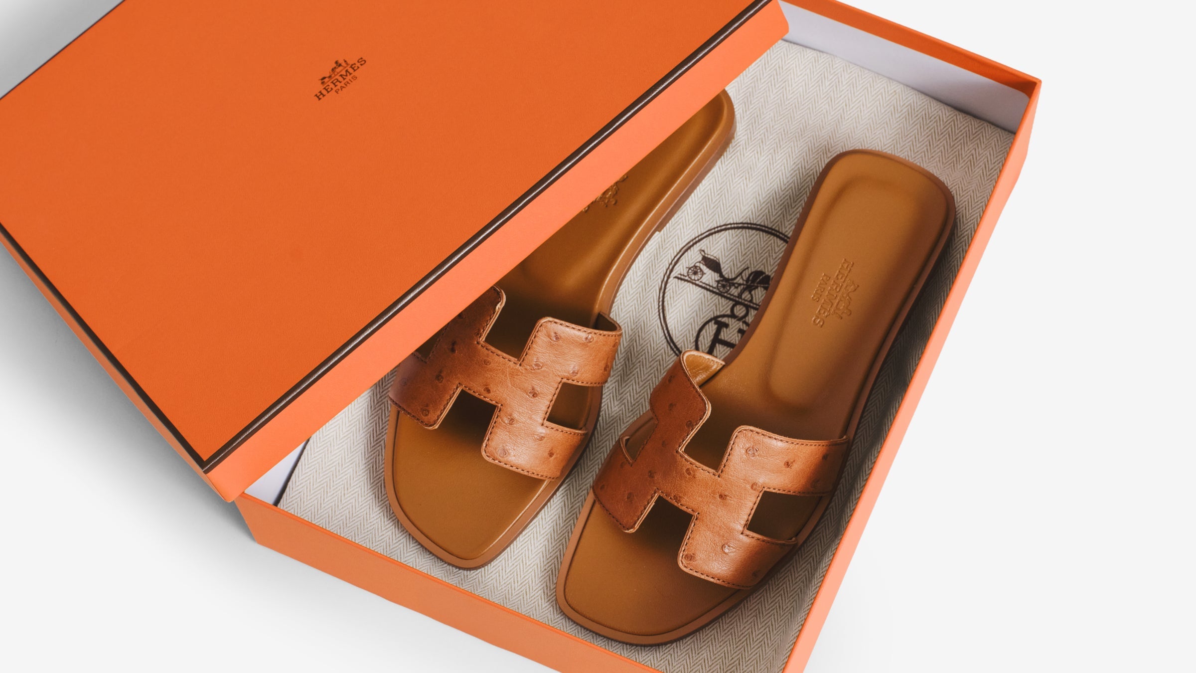 Hermes Oran sandals inside an orange Hermes shoebox 