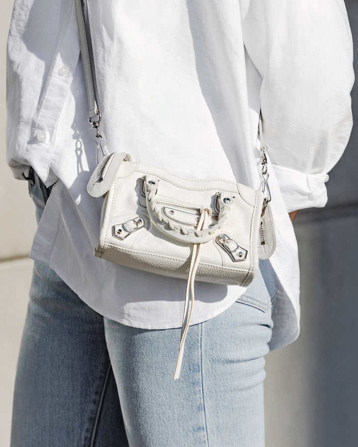 lifestyle image of model wearing white balenciaga classic city bag FASHIONPHILE