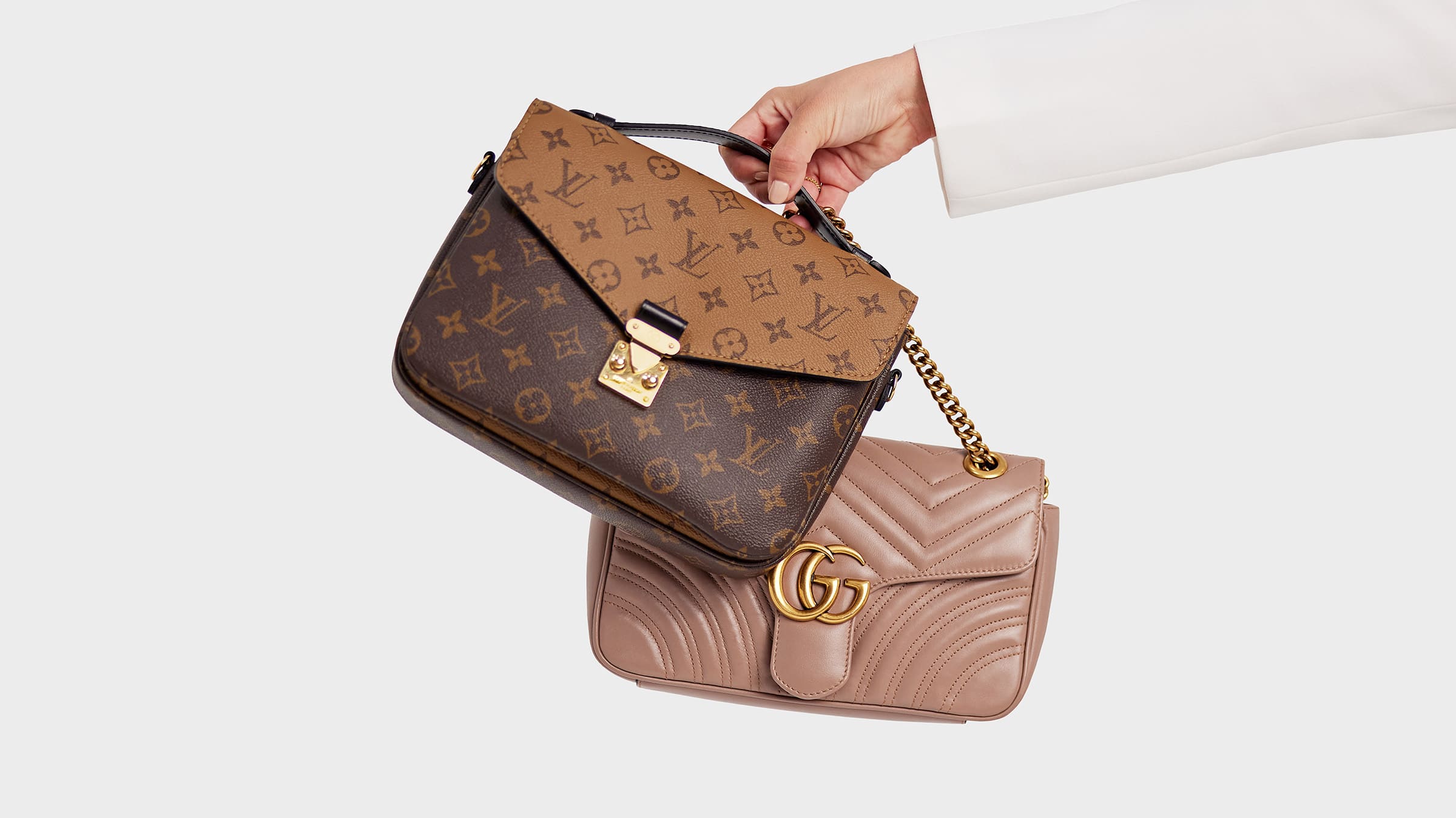 studio image of model holding louis vuitton pochette metis and gucci marmont shoulder bag FASHIONPHILE