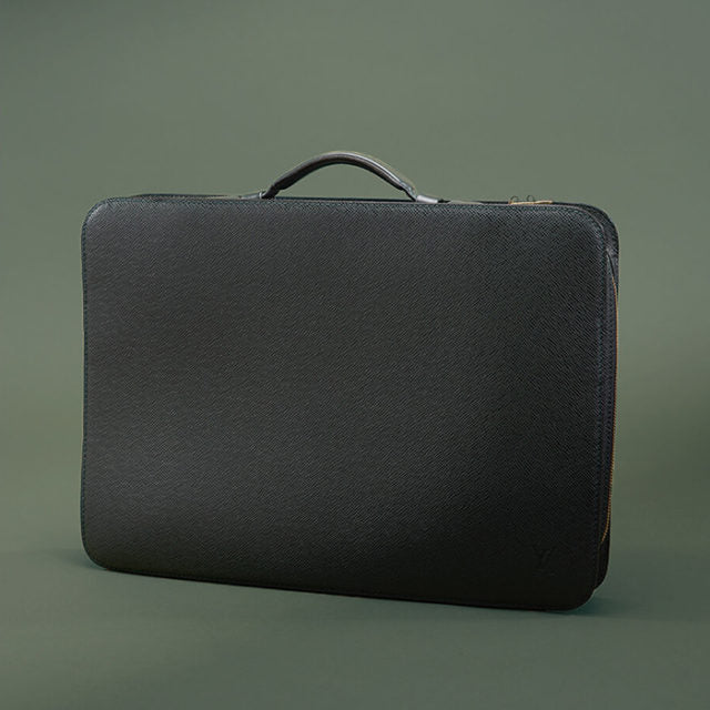 studio image of briefcase on green background FASHIONPHILE