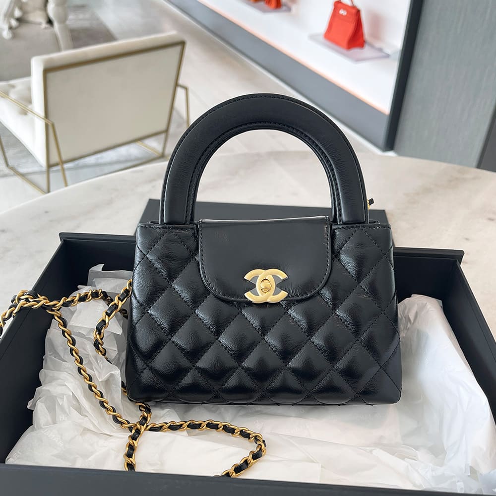 front view image of a black chanel nano kelly shopper bag inside the chanel box by FASHIONPHILE