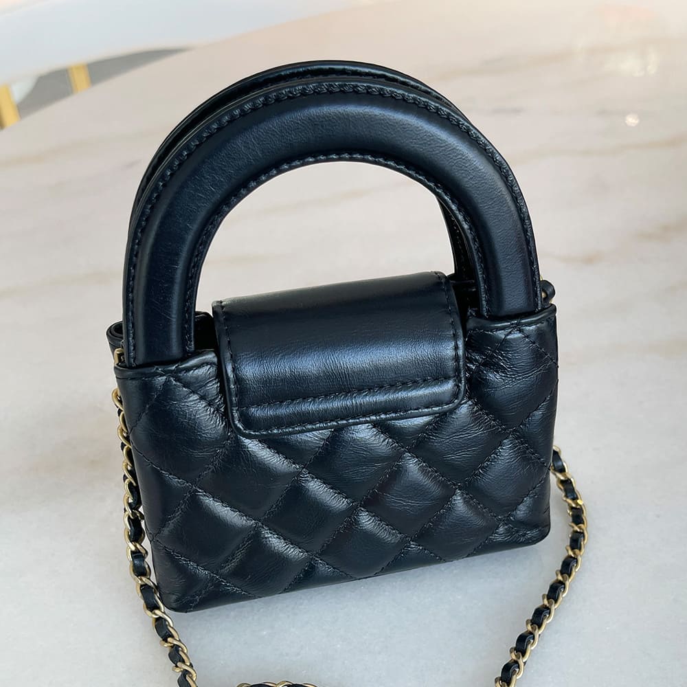 back view image of a black chanel mini nano kelly shopper bag by FASHIONPHILE