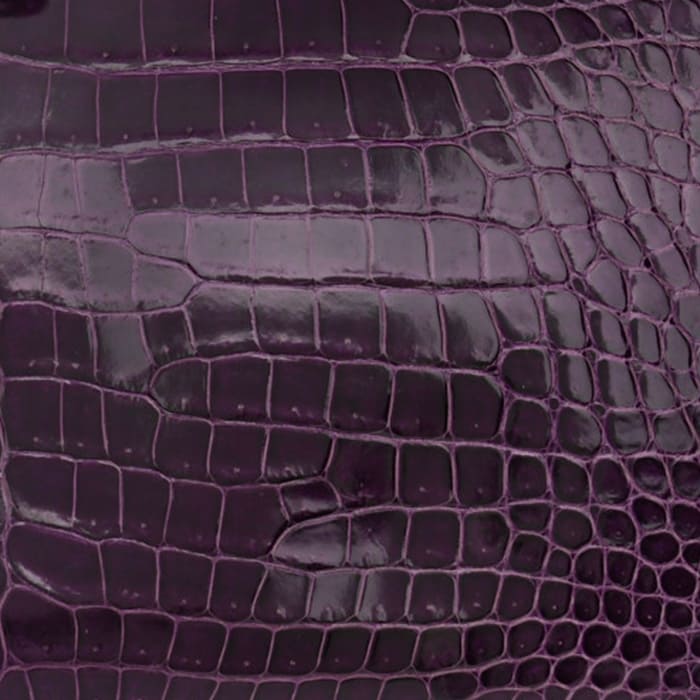 this is a close up swatch of hermes amethyst on shiny porosus crocodile leather by FASHIONPHILE