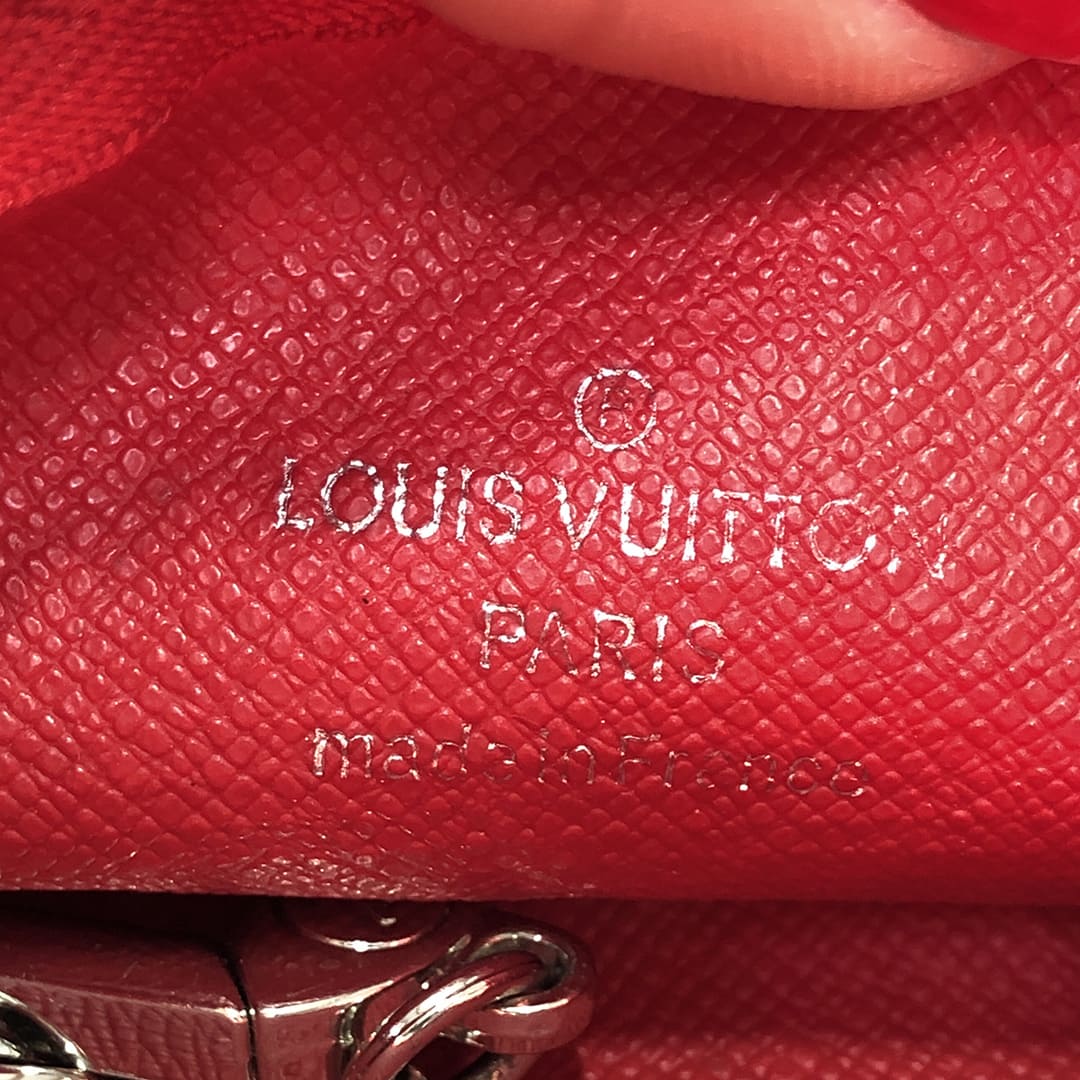 close up image of the interior of a fake louis vuitton key pouch with fake louis vuitton stamp by FASHIONPHILE