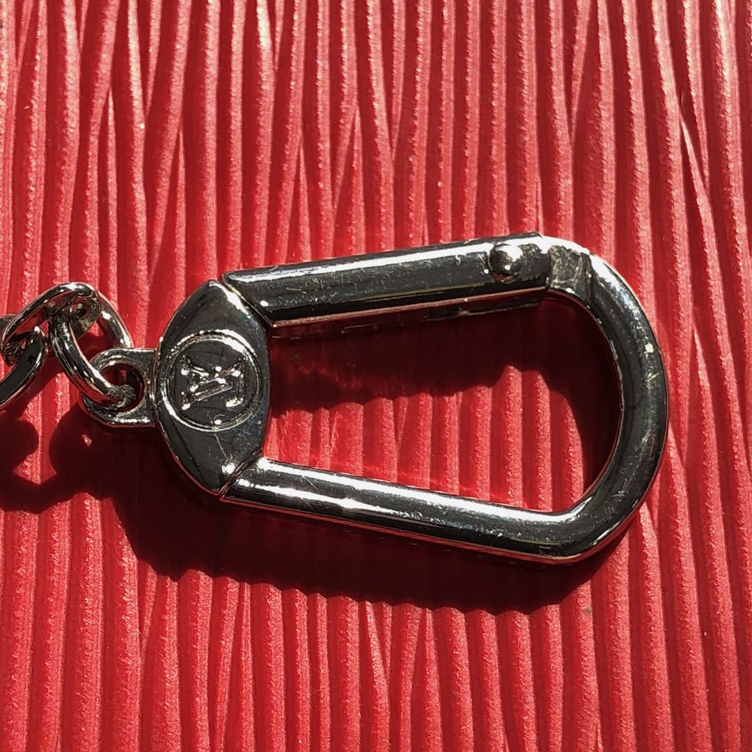 close up image showing the hardware on a fake louis vuitton key pouch by FASHIONPHILE
