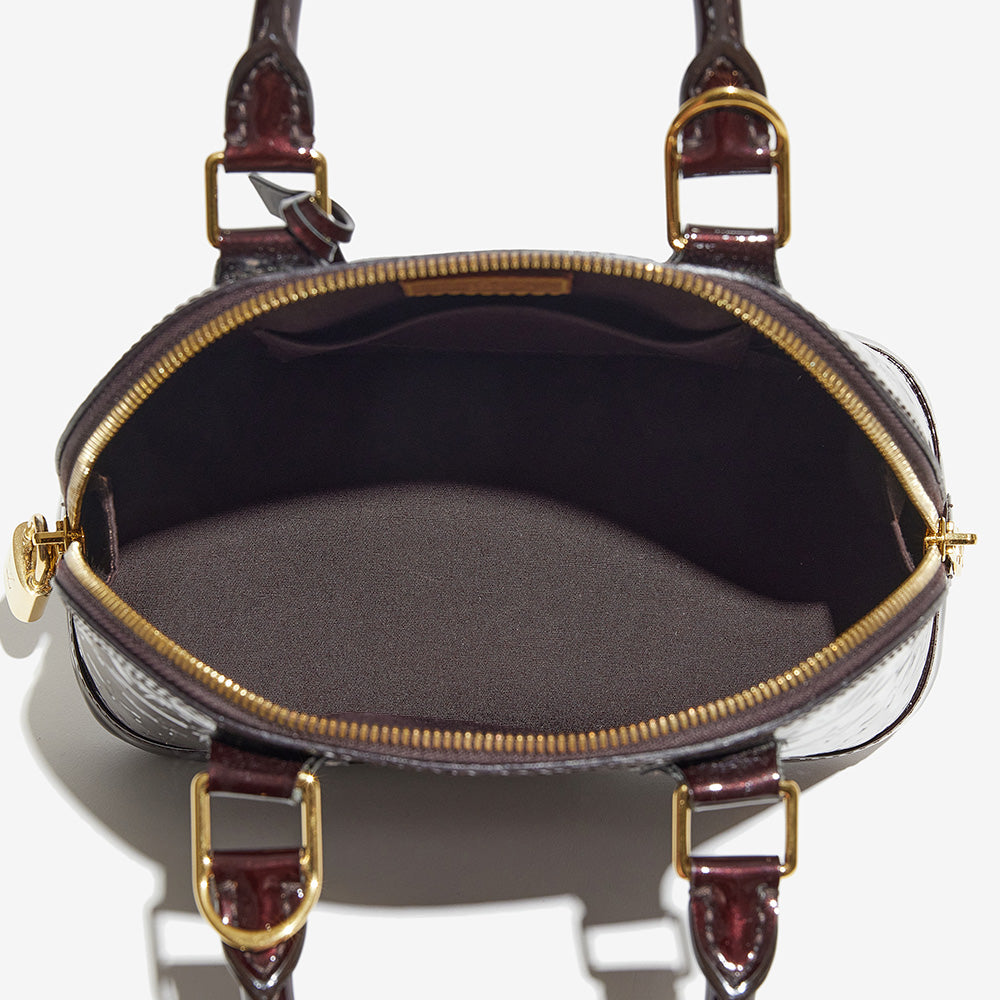 this is an image by FASHIONPHILE of an authentic vernis louis vuitton alma bb bag looking at the inside