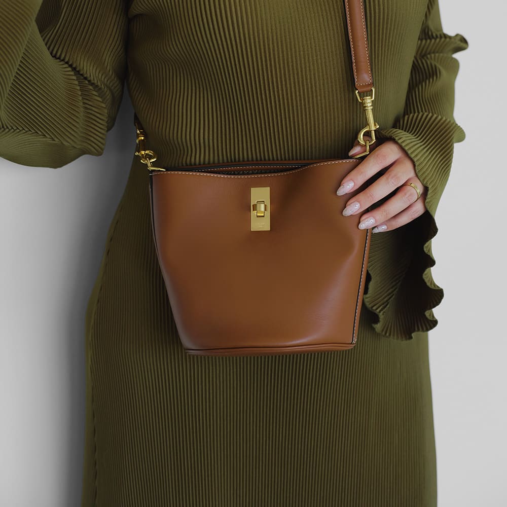 the celine 16 bucket bag in the color brown worn as a crossbody by FASHIONPHILE