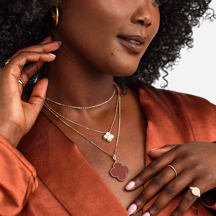 model styling fine jewelry pieces inclduing van cleef and arpels necklaces from the alhambra collection, a vca perlee ring and pomellato ring by FASHIONPHILE