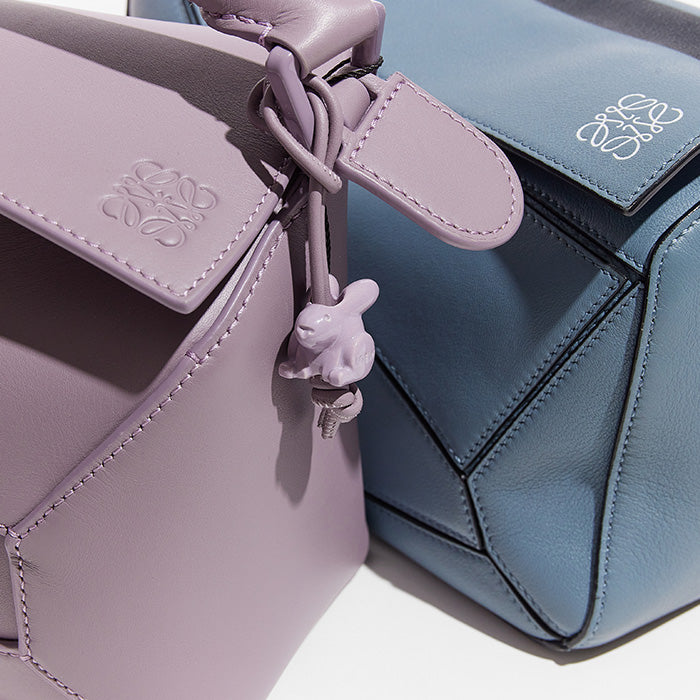 this is a close up image comparing the loewe puzzle bag with the loewe puzzle edge bag by fashionphile