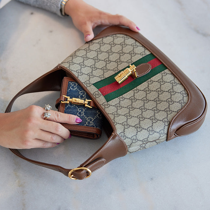 lifestyle image of model putting in a gucci wallet inside a gucci jackie 1961 hobo FASHIONPHILE