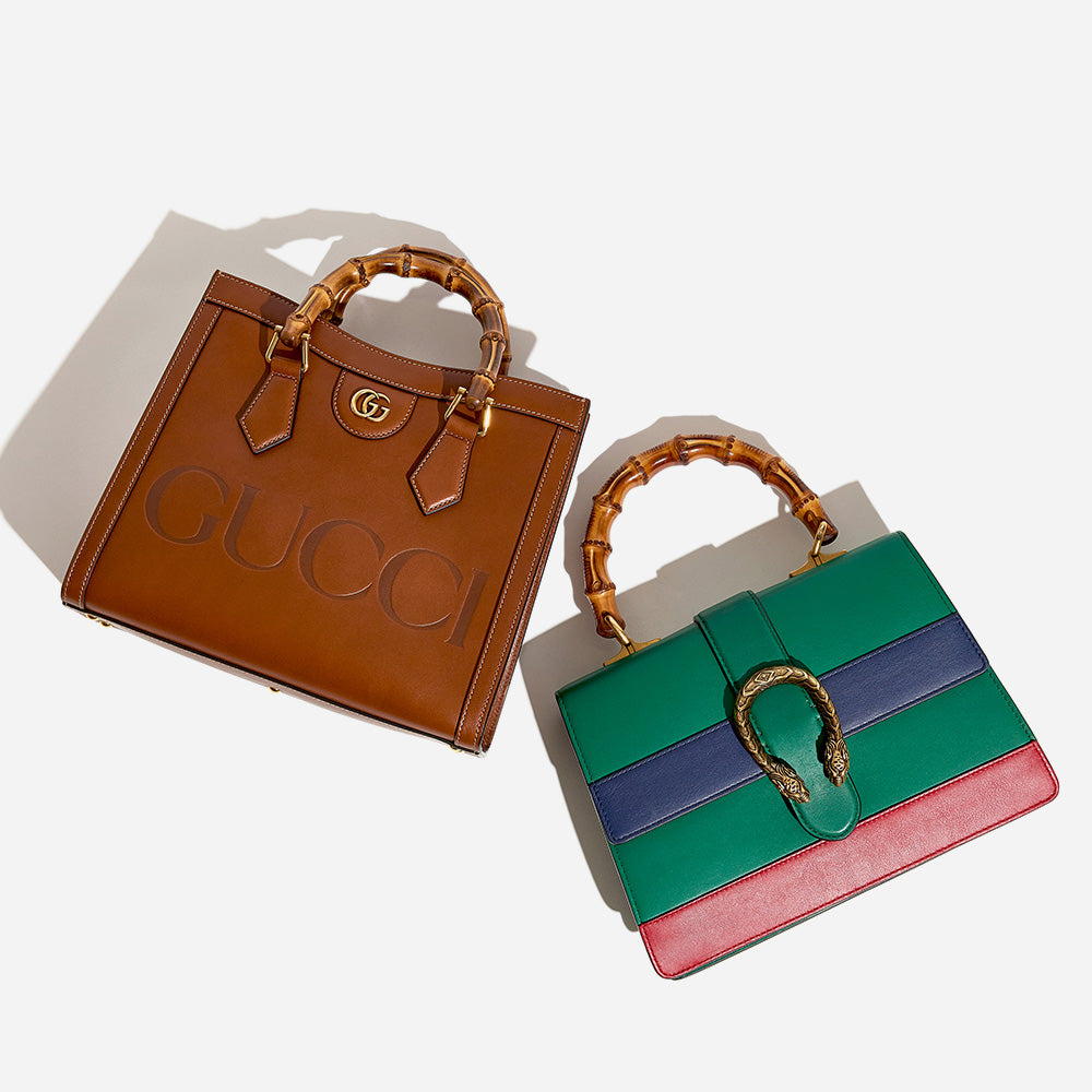 a flat lay image of a brown gucci diana bamboo tote and a tri-color gucci dionysus bamboo bag in the colors green, blue and red by FASHIONPHILE