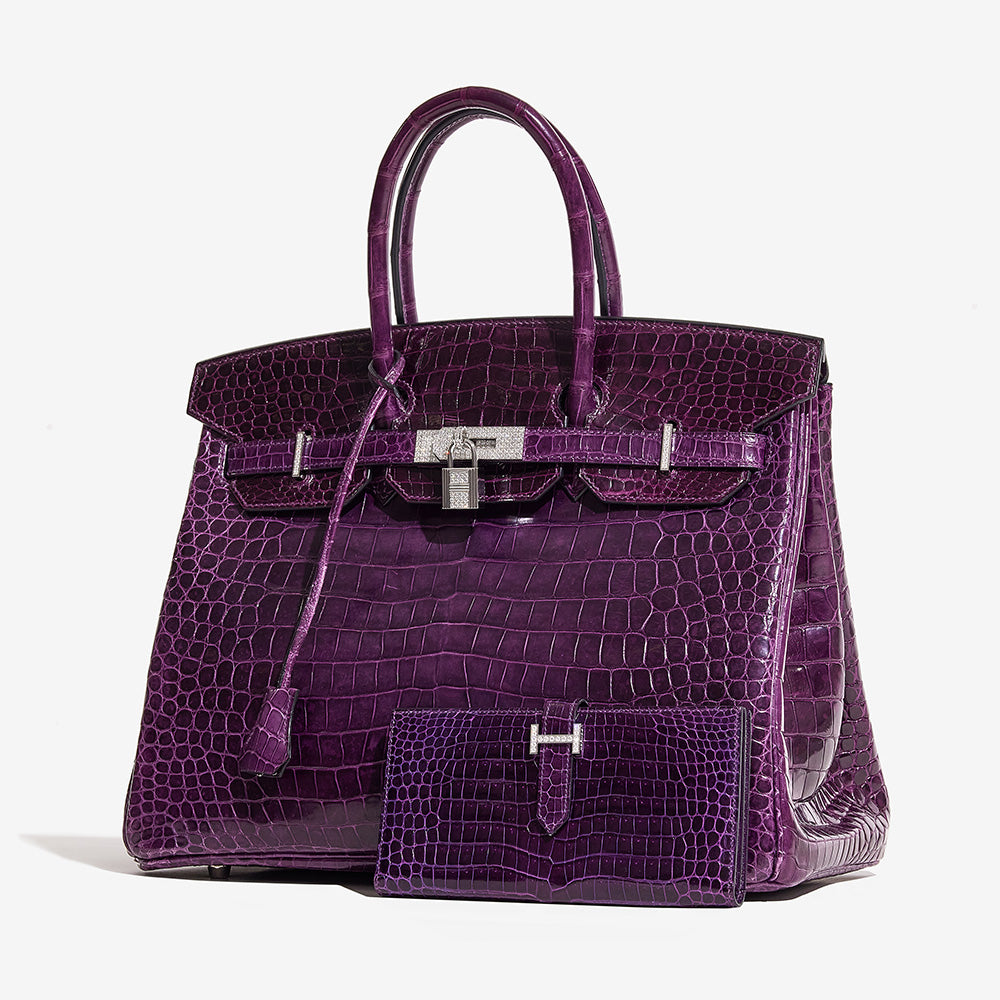 this is an image of an HERMES Shiny Porosus Crocodile 18K White Gold Diamond Birkin 35 in the color Amethyst by FASHIONPHILE