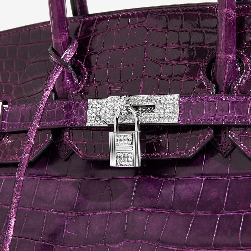 this is a close up image of an HERMES Shiny Porosus Crocodile 18K White Gold Diamond Birkin 35 in the color Amethyst by FASHIONPHILE
