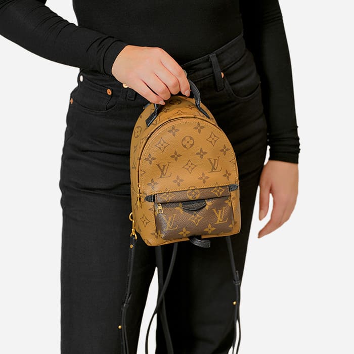 ways to wear the louis vuitton mini palm springs backpack with model wearing it as a top handle by FASHIONPHILE