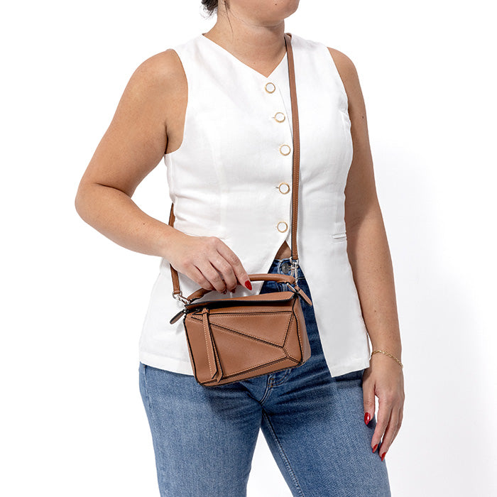 model wearing a brown mini loewe puzzle bag as a crossbody by FASHIONPHILE
