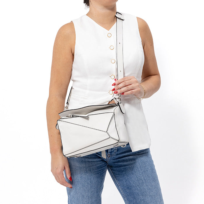 model wearing a white small loewe puzzle bag as a crossbody by FASHIONPHILE
