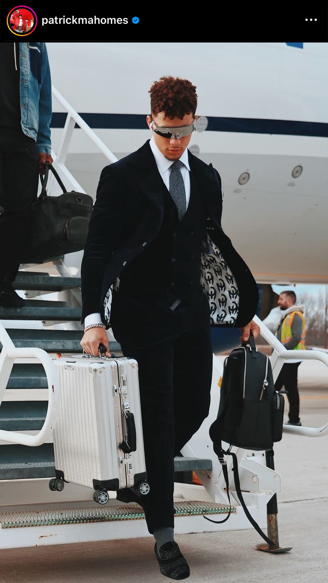 screenshot image of patrick mahomes kansas city chiefs quarterback carrying his rimowa suitcase and backpack off the private jet by FASHIONPHILE