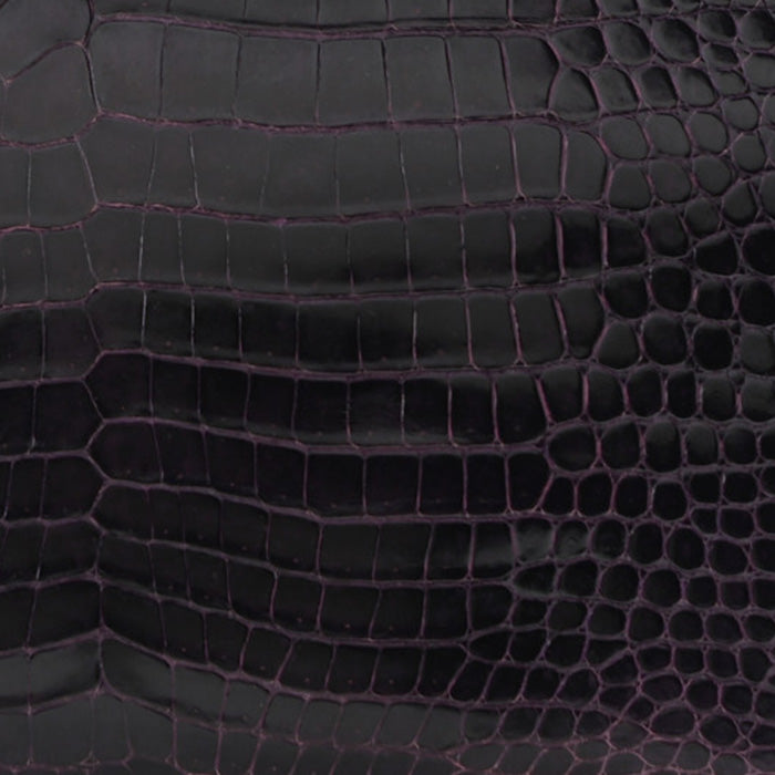 this is a close up swatch image of hermes prunoir color on shiny porosus crocodile leather by FASHIONPHILE