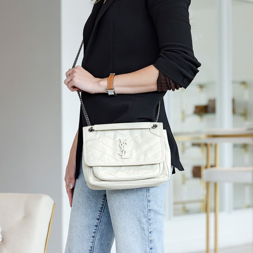 this is an image of a model wearing the baby saint laurent niki bag as a crossbody by FASHIONPHILE