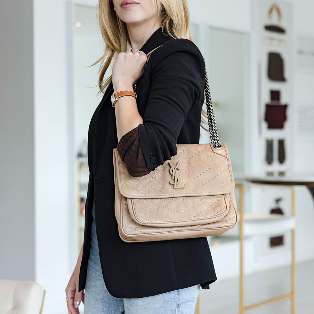 this is an image of a model wearing the medium saint laurent niki bag as a shoulder bag by FASHIONPHILE