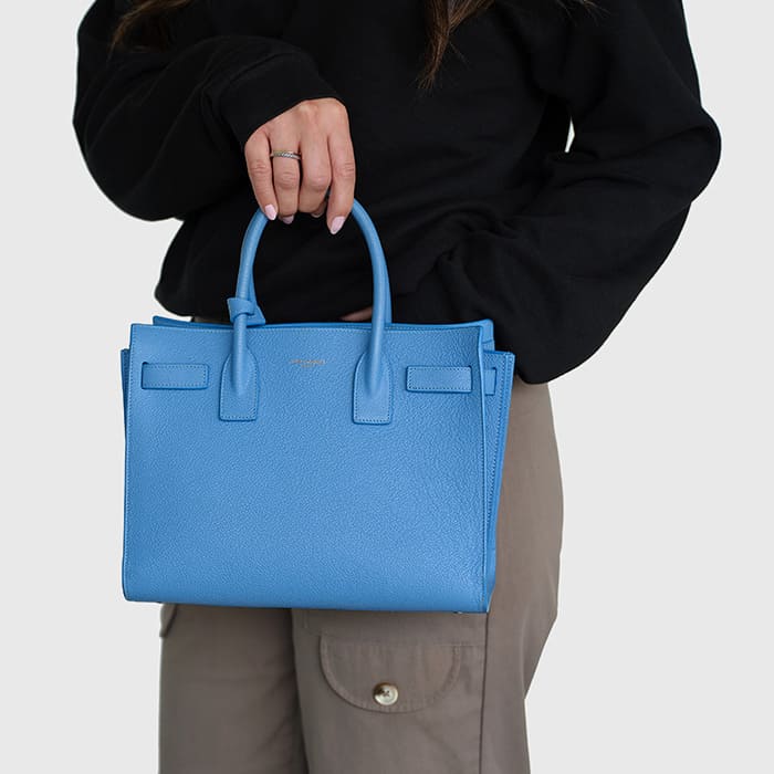 blue baby sac de jour worn as a top handle bag by FASHIONPHILE