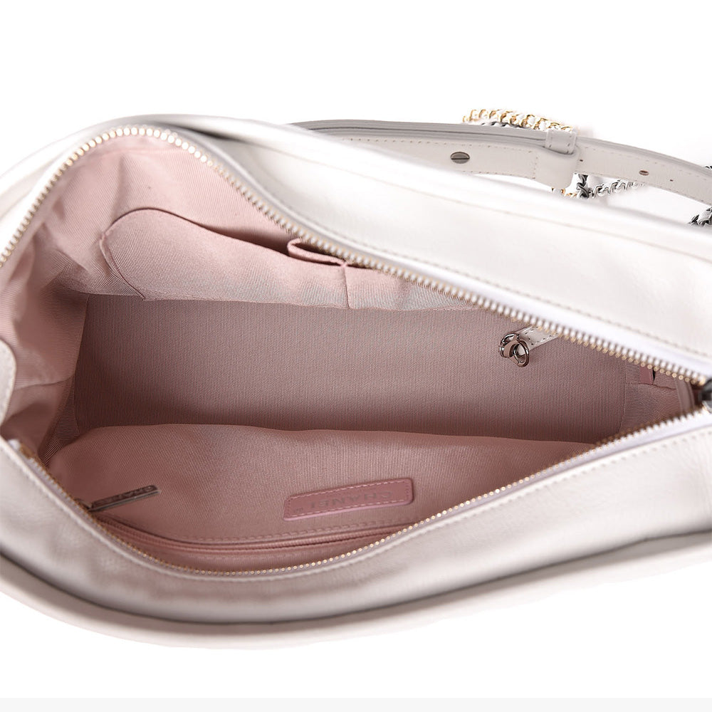 this is a top down view image of an authentic white chanel gabrielle hobo bag showing the lining by fashionphile