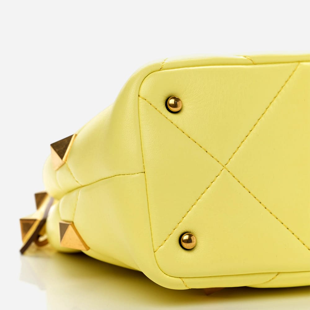 image of the bottom of an authentic valentino garavani bag showing the stitching and placement of the hardware by FASHIONPHILE