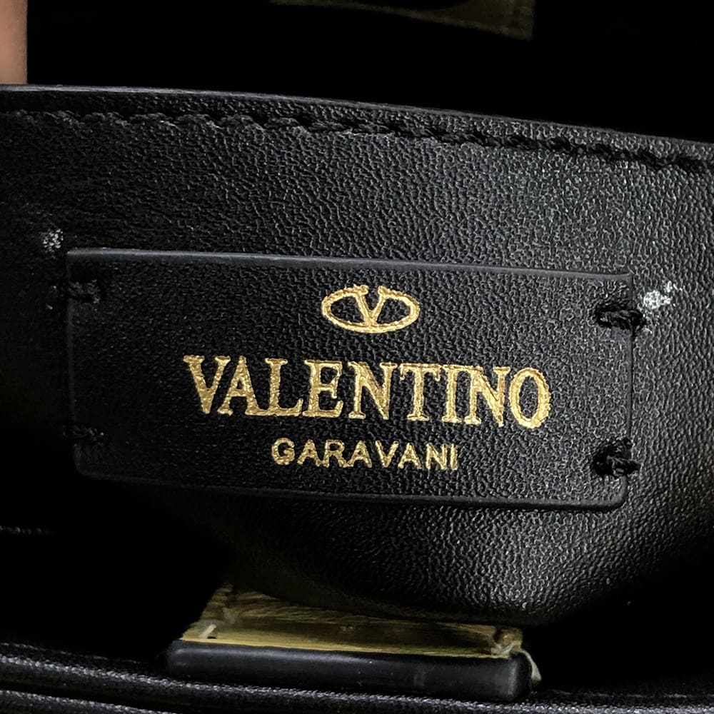close up of fake valentino garavani interior brand foil stamp by FASHIONPHILE