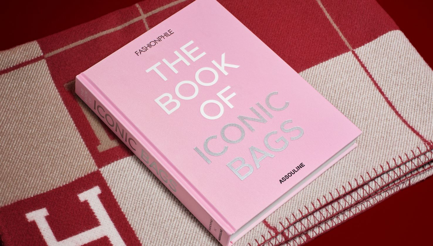 the FASHIONPHILE The Book of Iconic Bags lying on top of a red Hermes Avalon Blanket