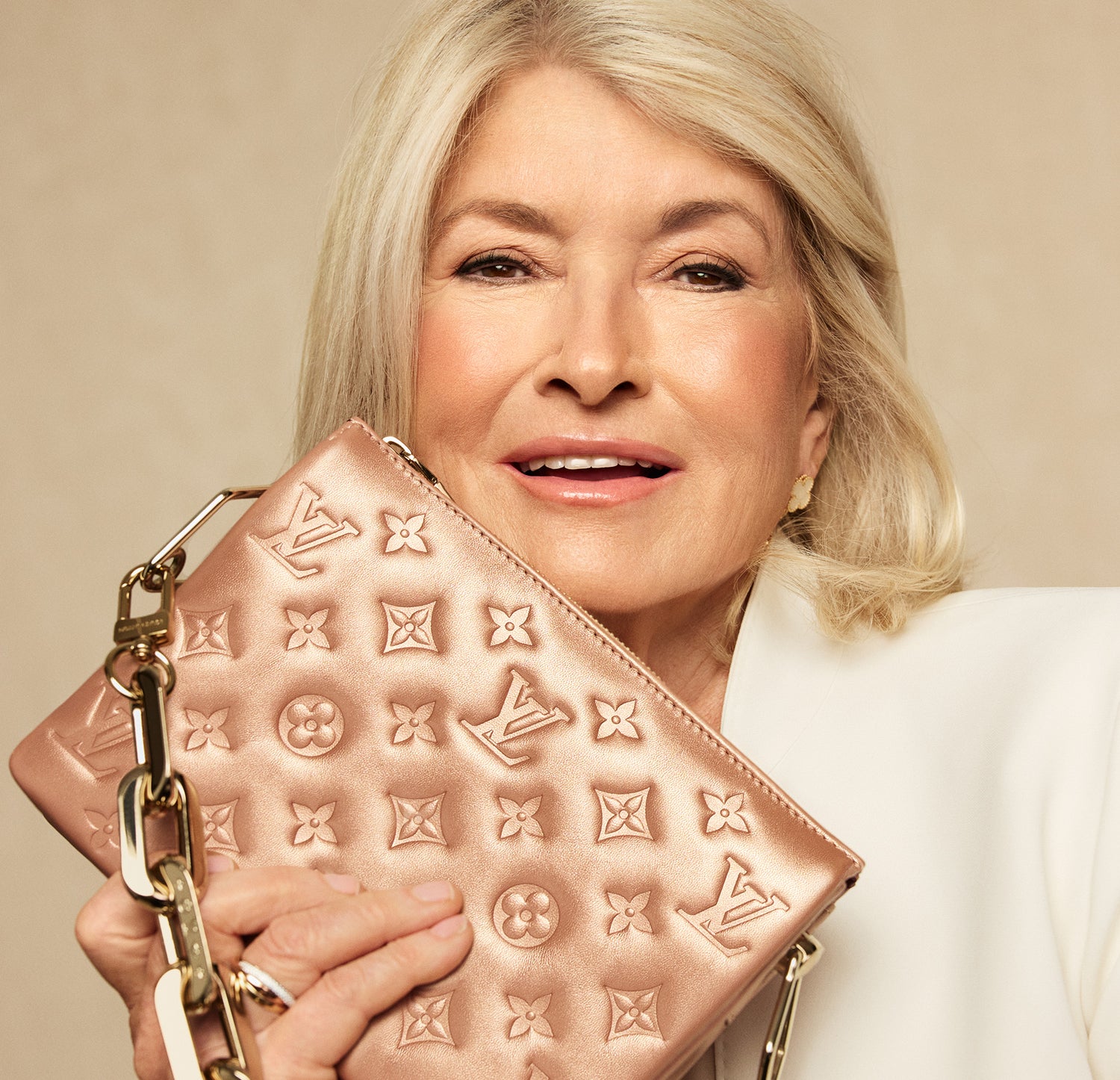Martha Stewart in a white suit holding a LOUIS VUITTON Metallic Lambskin Embossed Monogram Coussin BB Pink Gold 