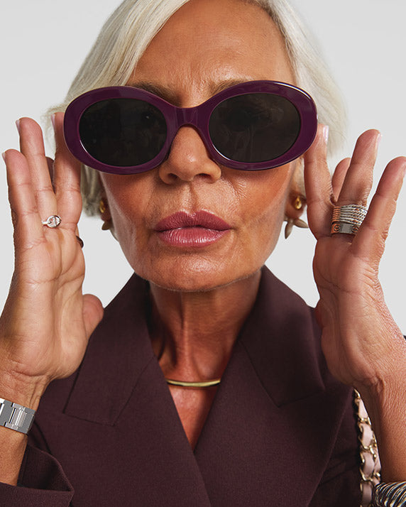 Grece Ghanem facing forward and holding burgundy Celine sunglasses to her face