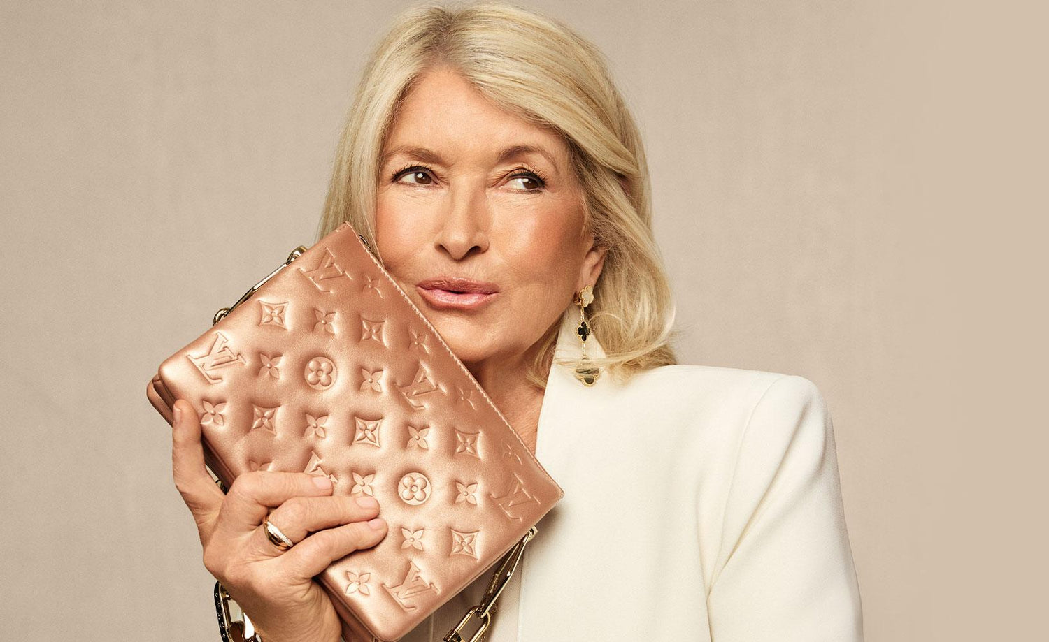 Martha Stewart in a white suit holding a LOUIS VUITTON Metallic Lambskin Embossed Monogram Coussin BB Pink Gold