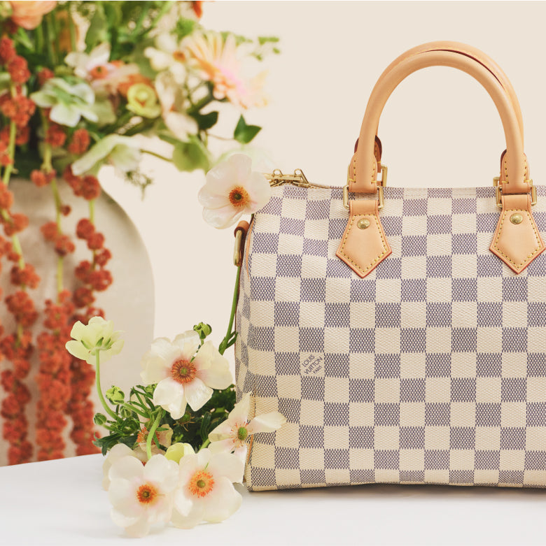One Louis Vuitton Damier Azur Speedy with flowers in the background