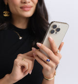 a woman wearing a black dress and holding an iPhone