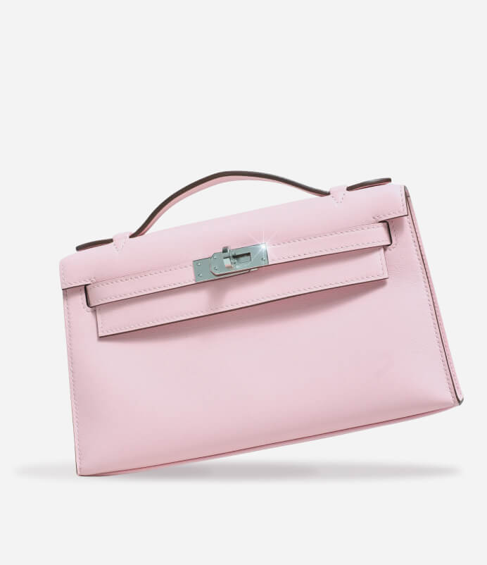 A light pink leather handbag with a top handle and silver-tone hardware, photographed on a clean white background.