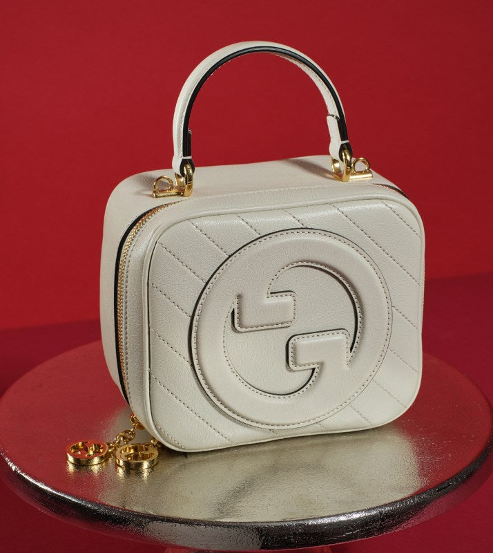 one Gucci Sakai Be Green Calfskin Diagonal Stitched Blondie Top Handle Bag Mystic White on a serving tray