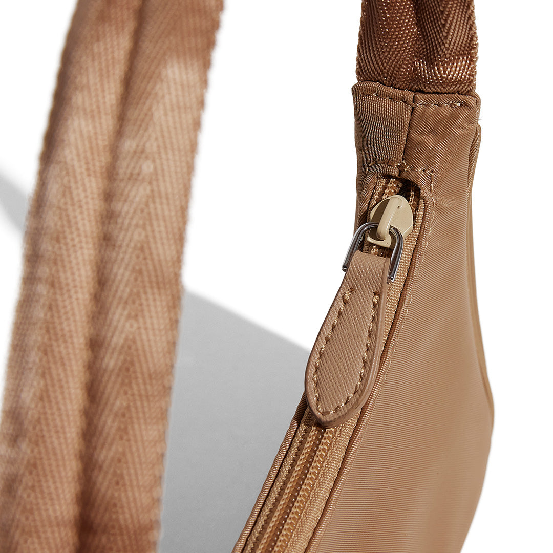 this is an image by FASHIONPHILE of a fake Prada Mini Re-Edition bag 2000 in beige