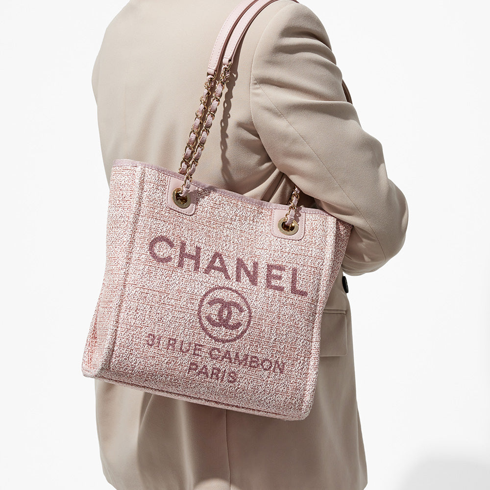this is an image by FASHIONPHILE of a model wearing a pink mini chanel deauville tote on her shoulder